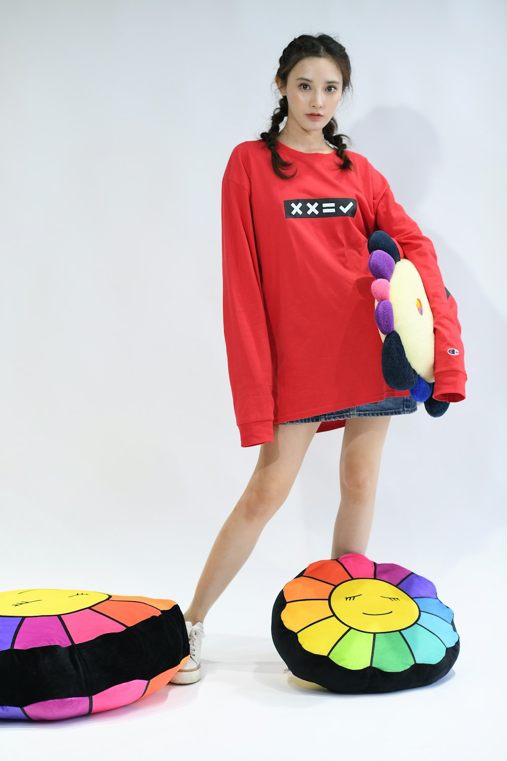 a woman in a red shirt is standing next to a colorful bean bag