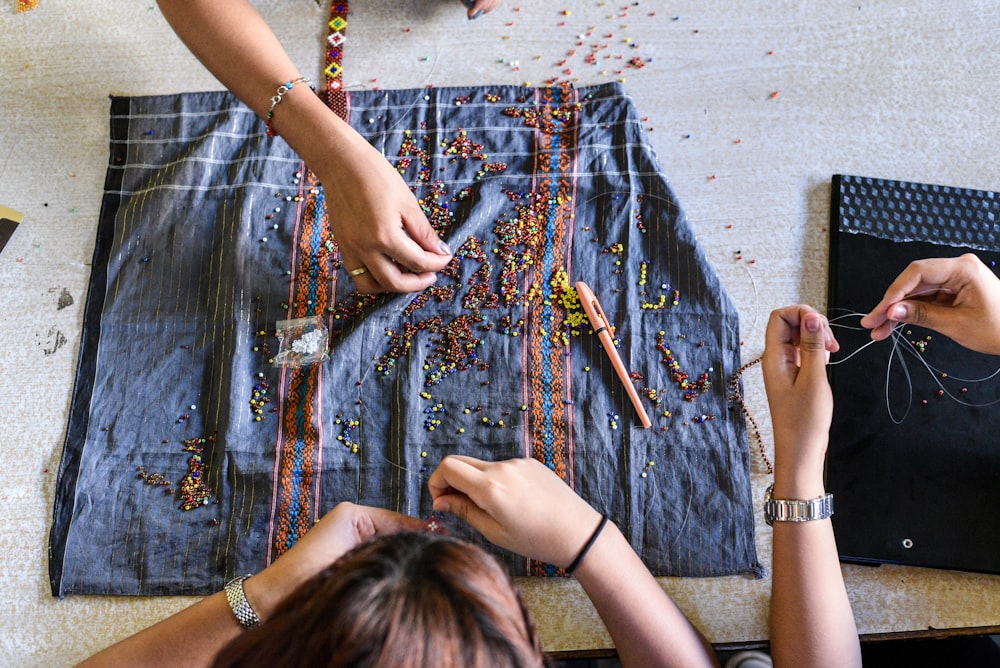 three person doing arts on top of table