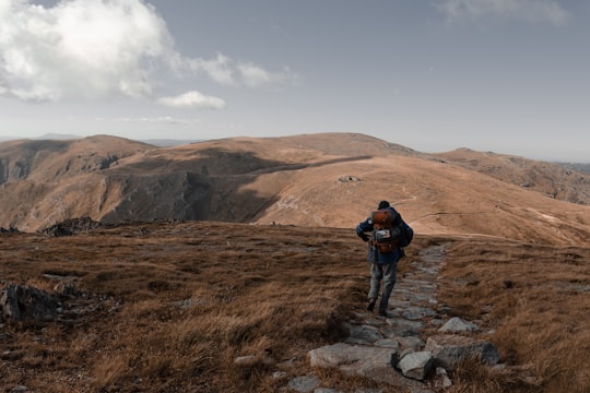 person carrying backpack walking on stone pathway in Kosciuszko National Park Australia