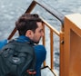 man in backpack sitting near staircase