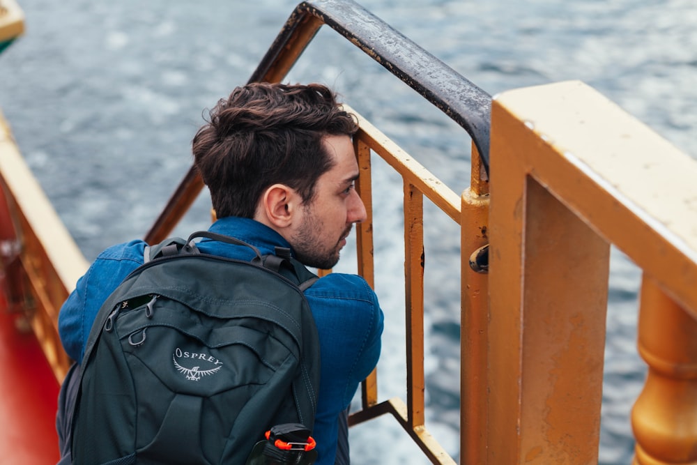 man in backpack sitting near staircase