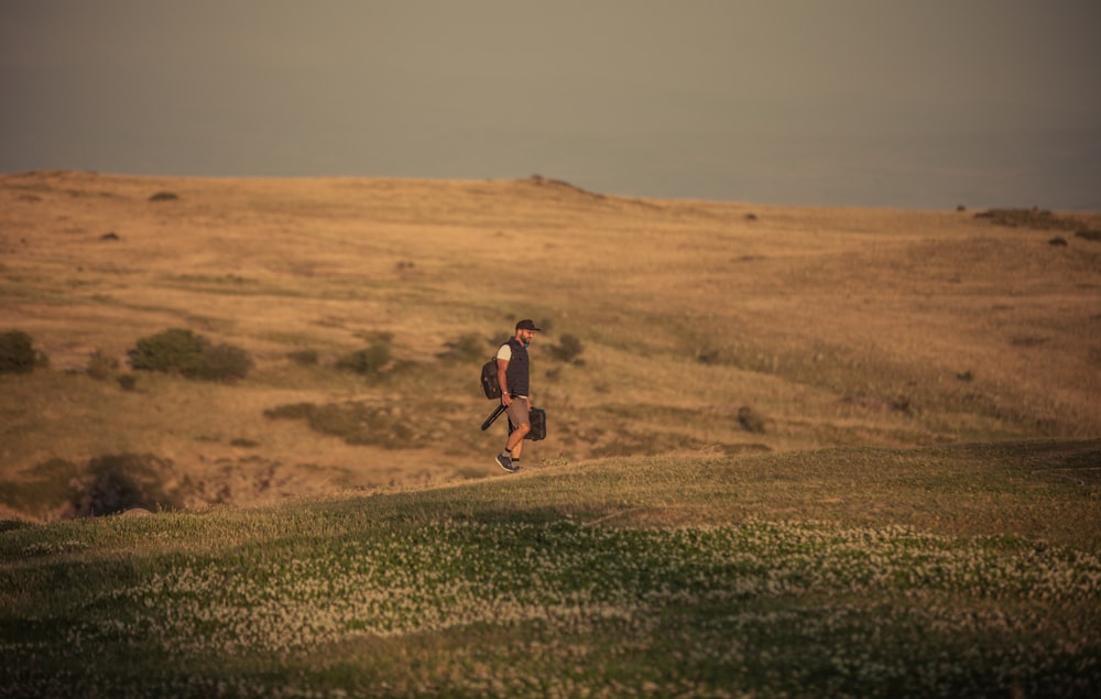 man walking along open field