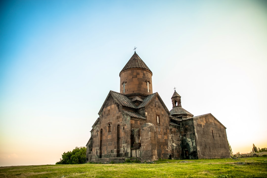 brown concrete church on green field at daytime