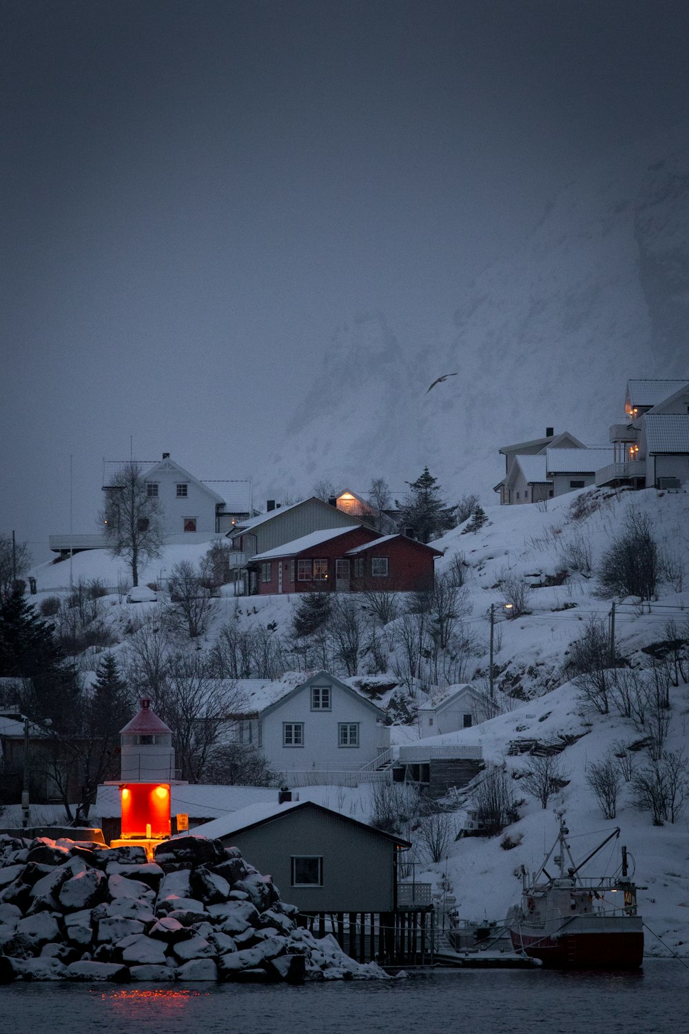 tower with orange light on village covered with snow