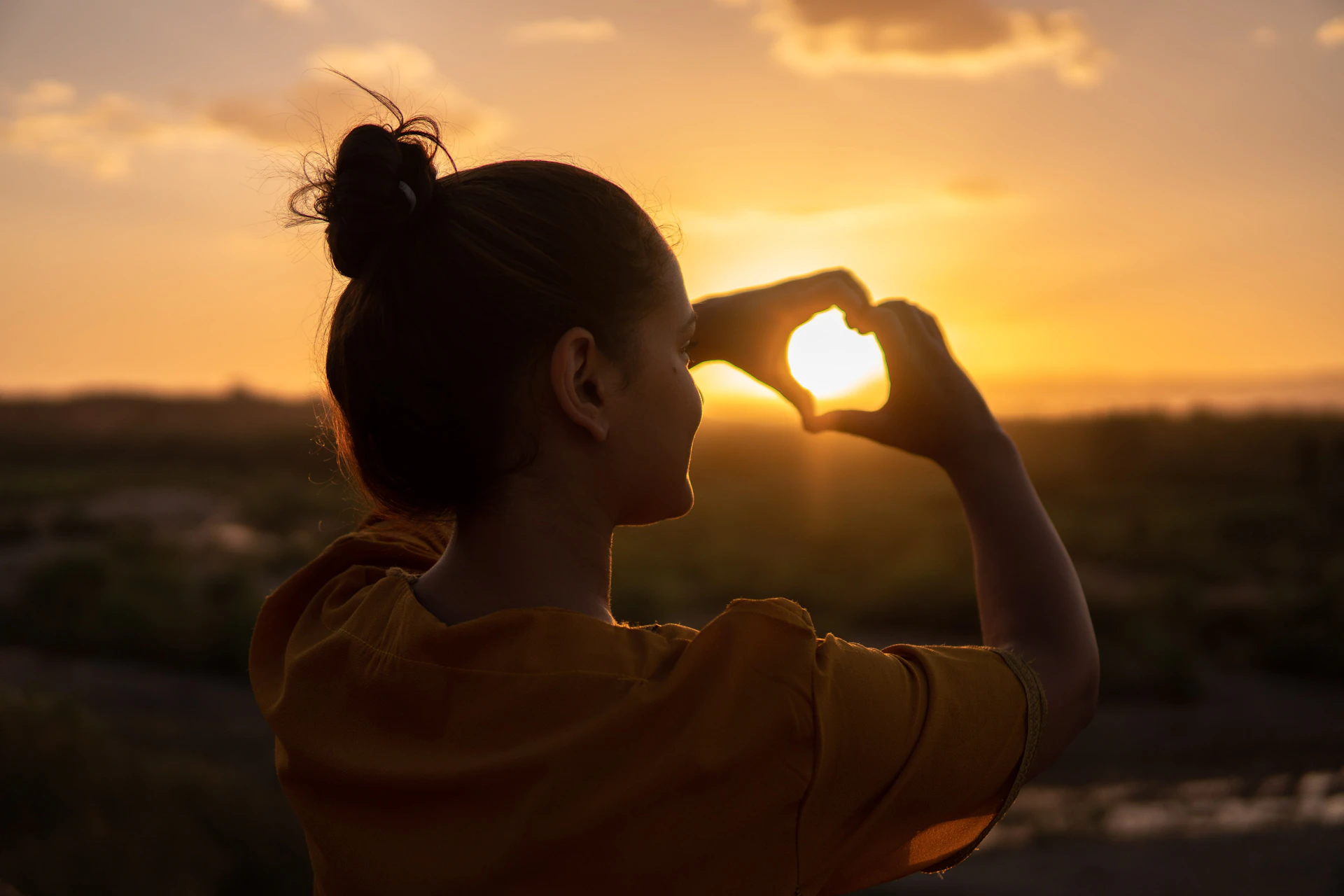 Photographer standing in a sunlit forest clearing during golden hour
