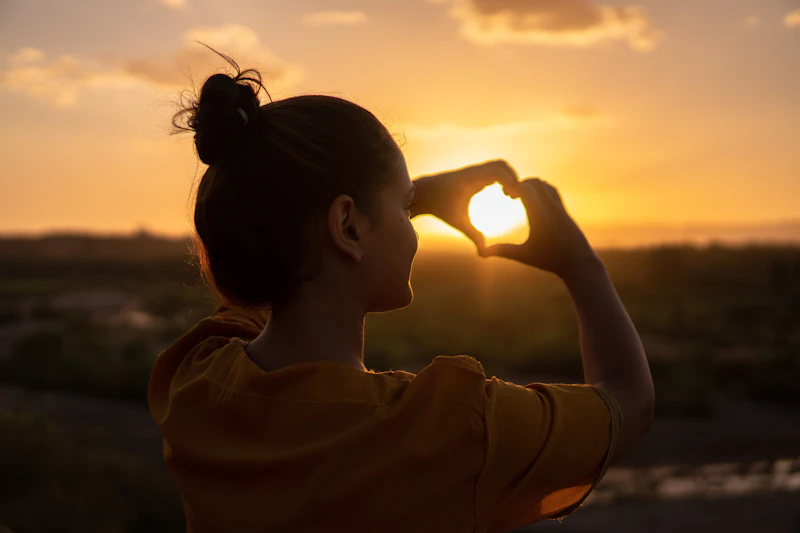 Woman standing overlooking the forest during golden hour