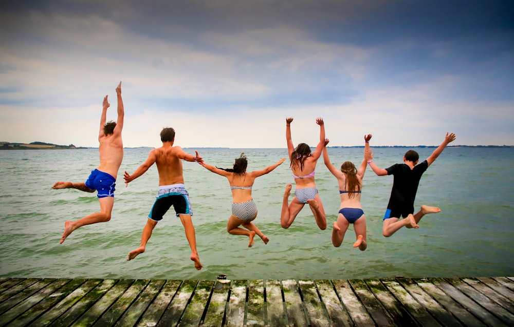 three women and three men jumps onto water