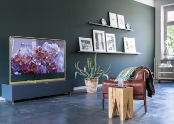 turned-on television in front of leather sofa chair