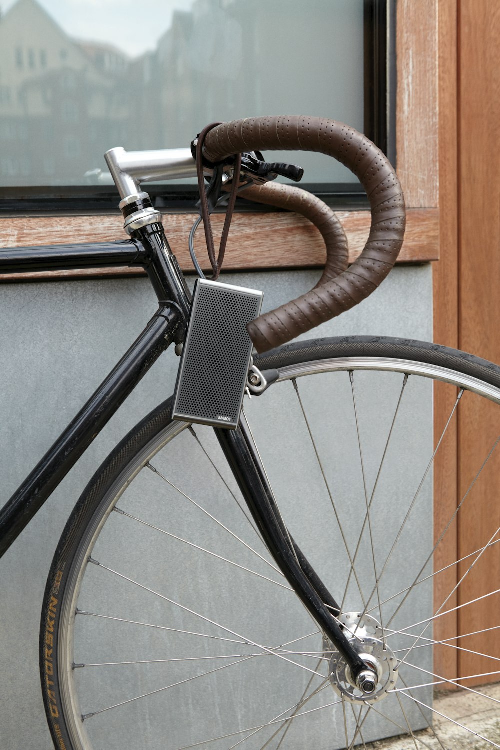gray and black road bike leaning on brown and gray concrete wall