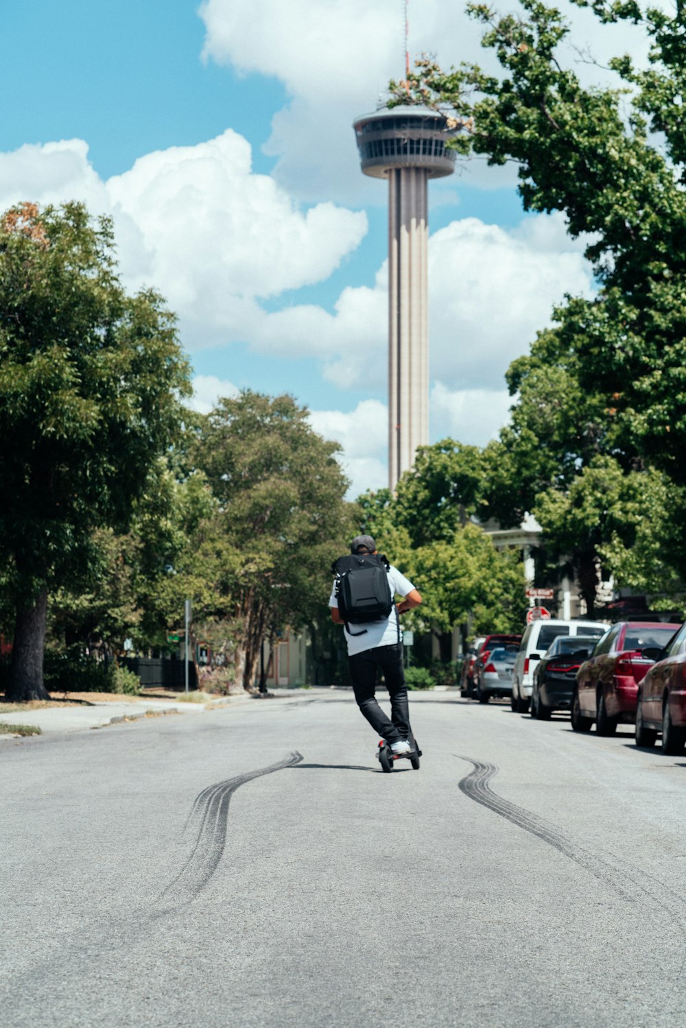 homem andando chute scooter monumento nas proximidades