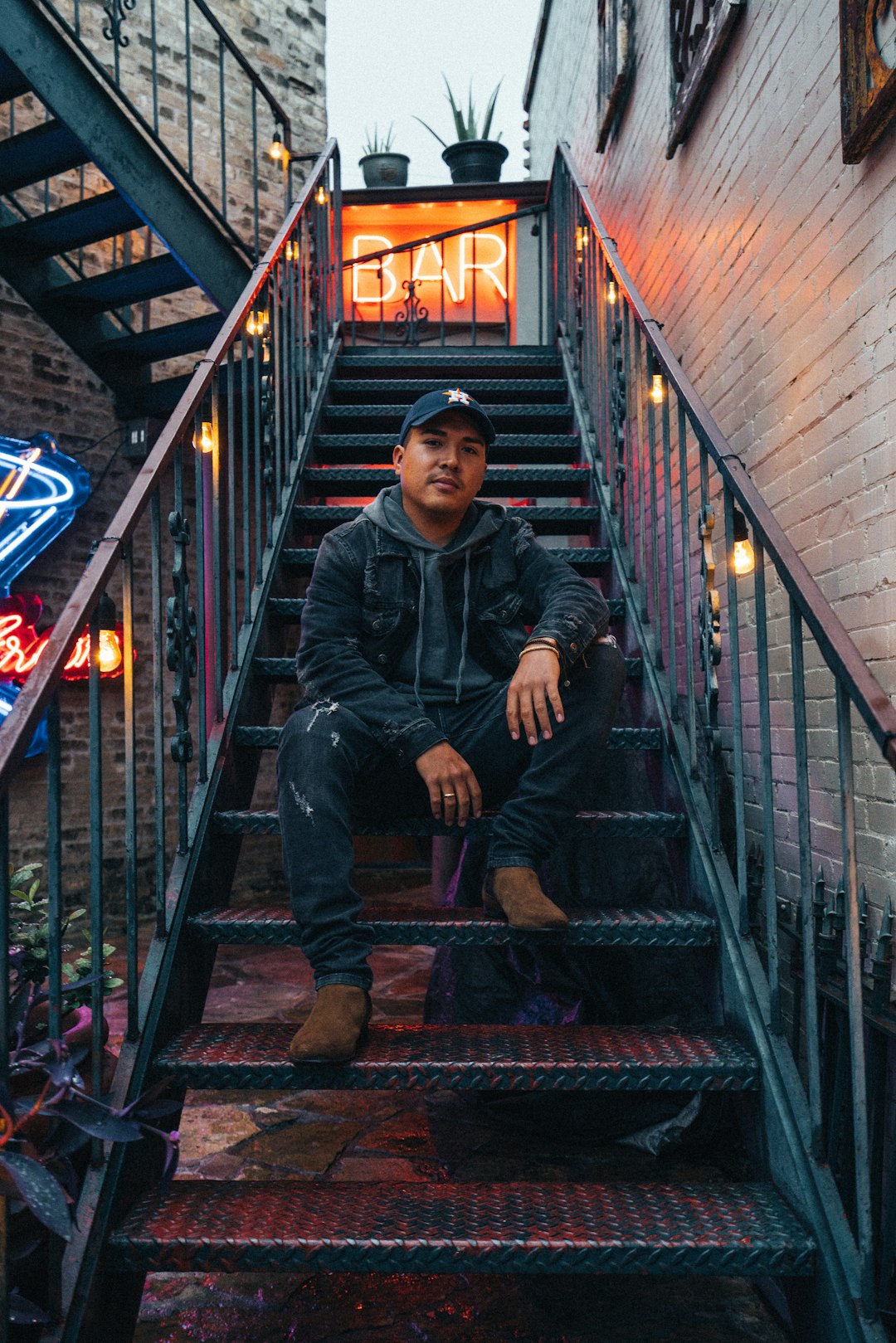 man sitting on black metal stair