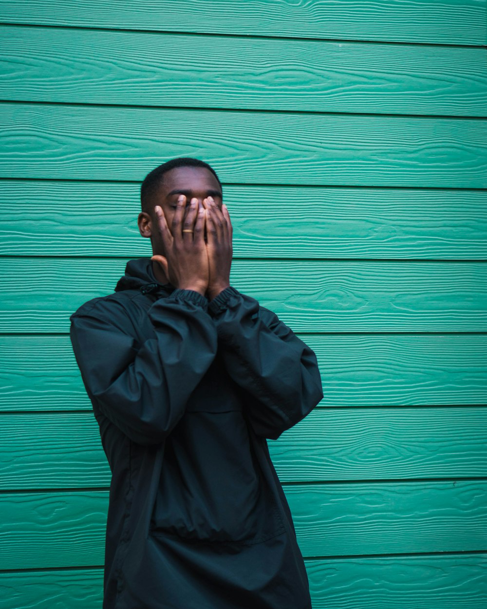 man standing covering her face