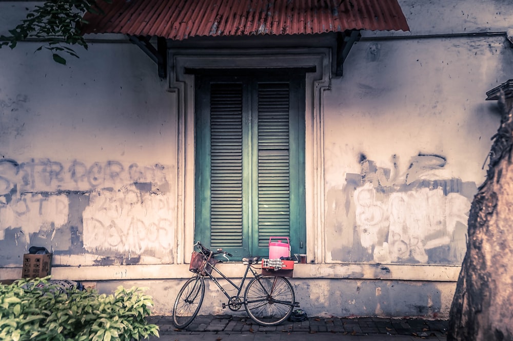 bicicletta appoggiata su parete bianca