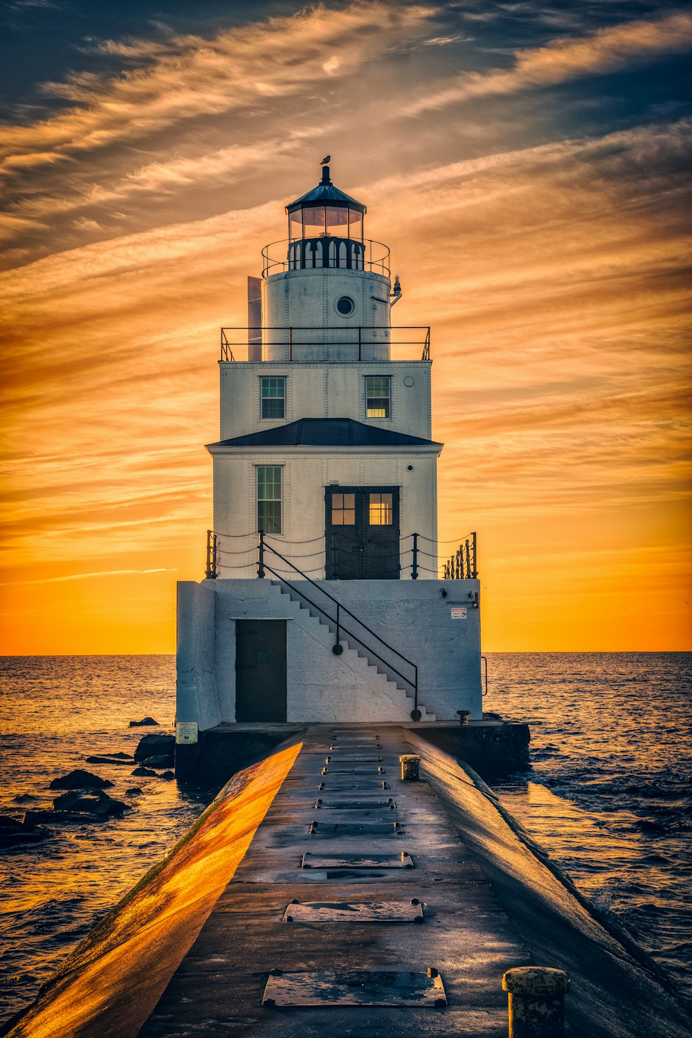 lighthouse surrounded by body of water during golden hour