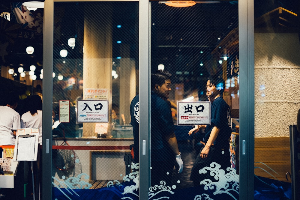 two man standing near the glass wall