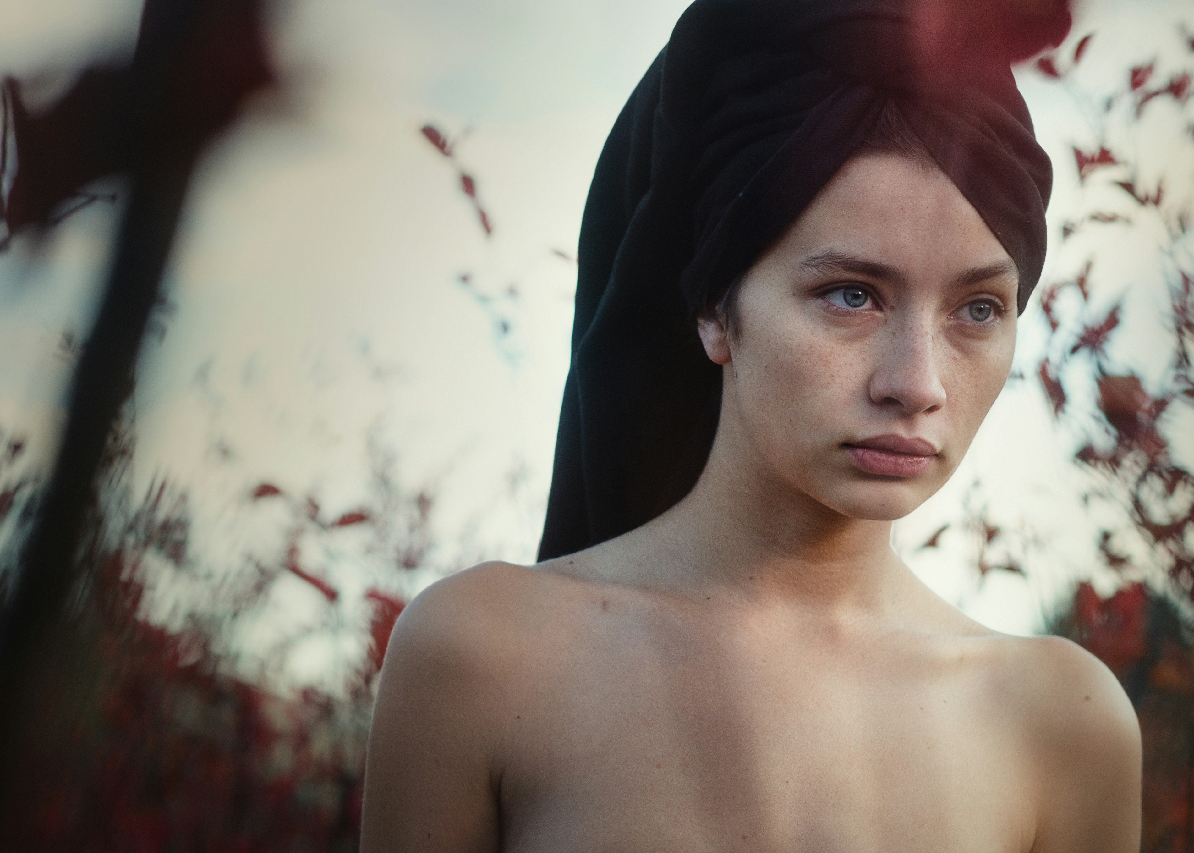 one unknown celebrity standing beside plants