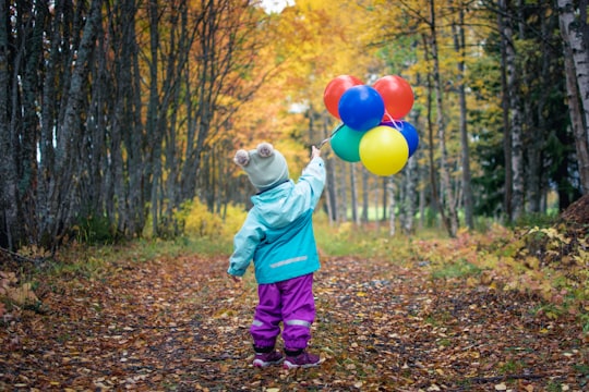 toddler holding balloons in Östersund Sweden