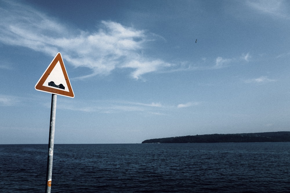 red and white tidal wave warning sign by the beach