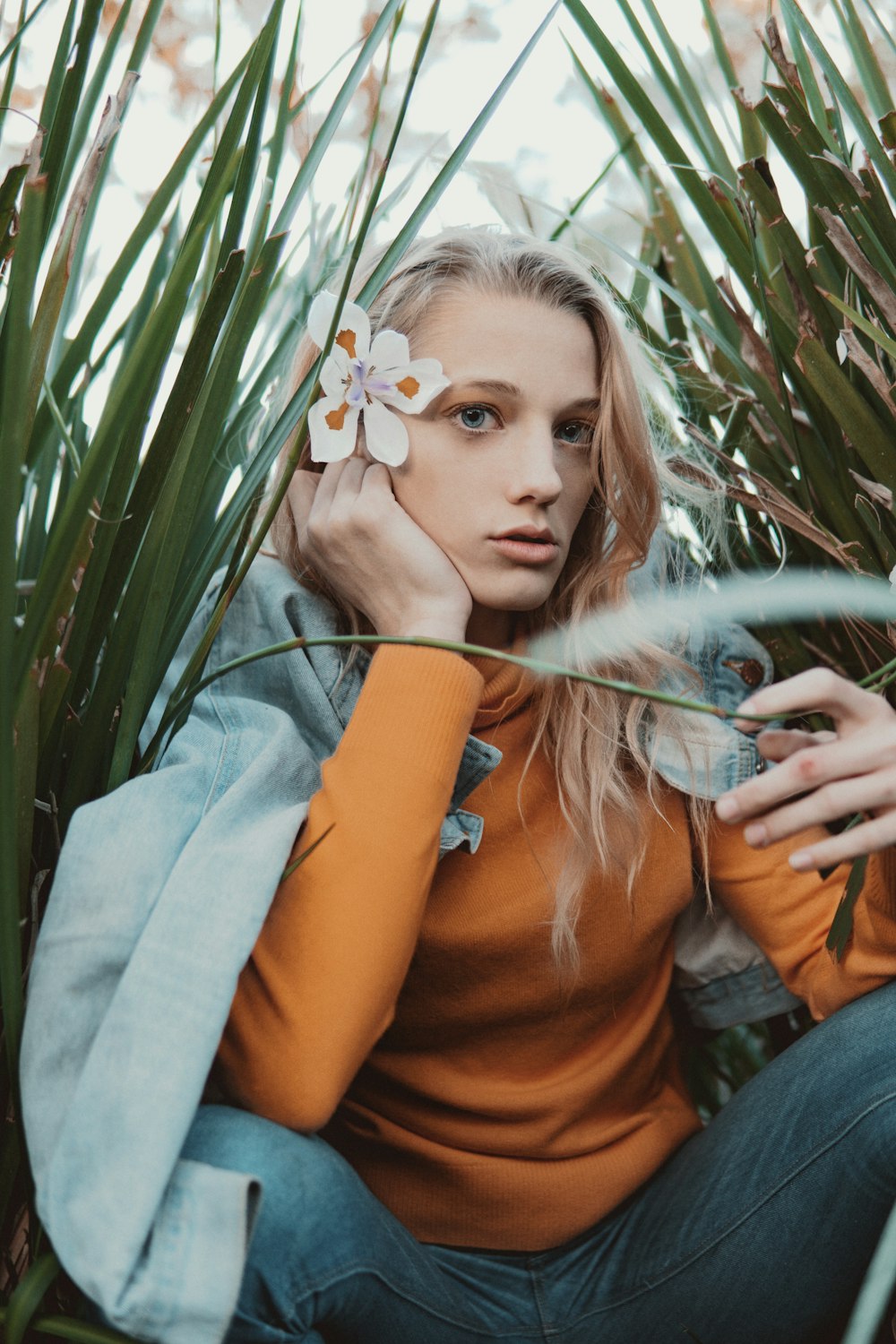 woman sitting between long grass