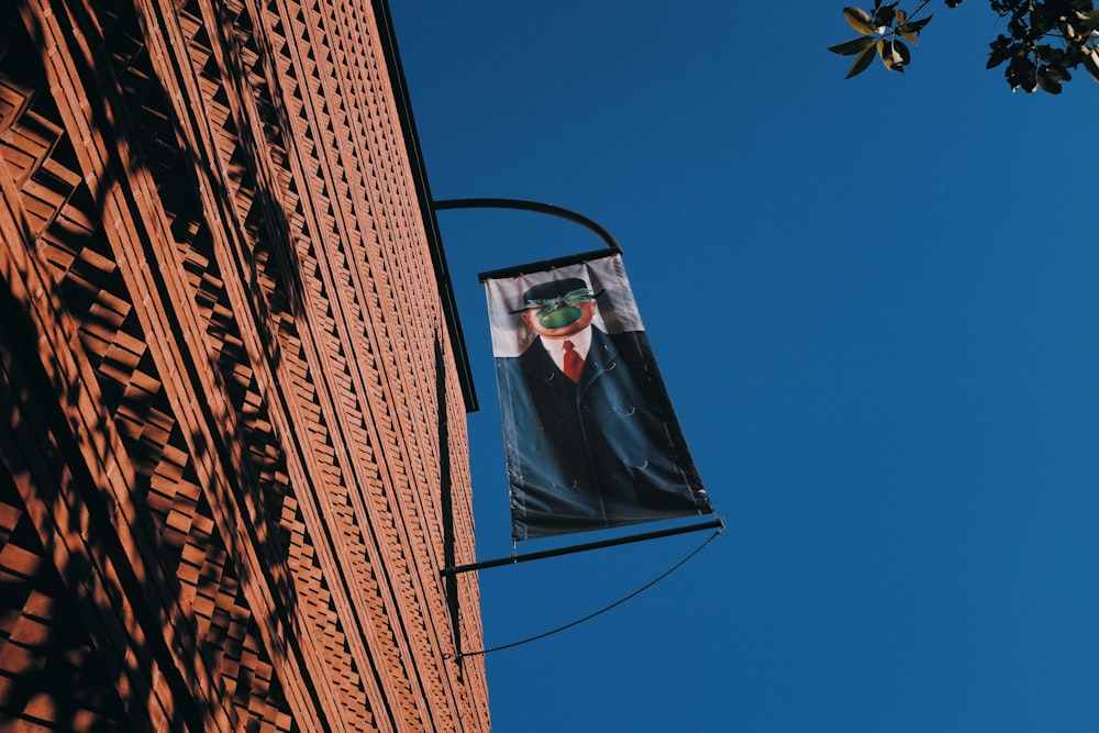 blue and white flag hanging beside brown building during daytime