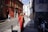 woman walking beside white and red concrete house