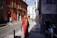 woman walking beside white and red concrete house