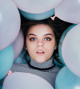 woman wearing striped turtle-neckline surrounded balloons