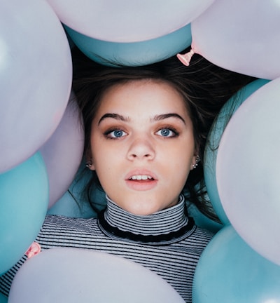 woman wearing striped turtle-neckline surrounded balloons