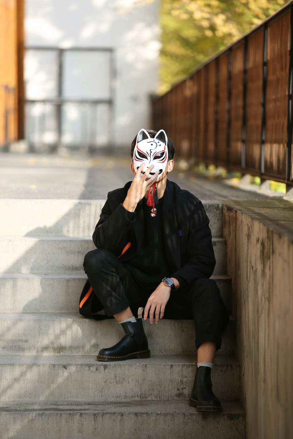 person wearing white and black mask sitting on stair