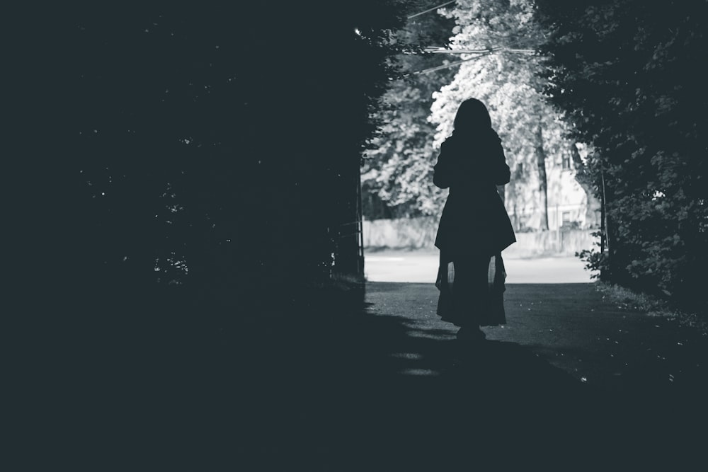 silhouette of woman walking at the pathway