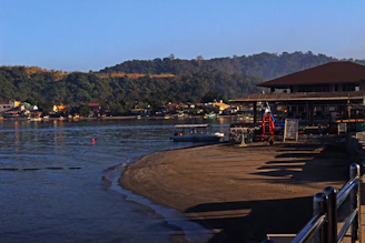 Tranquil riverside scene in Kasol with cozy cafés lining the shore.