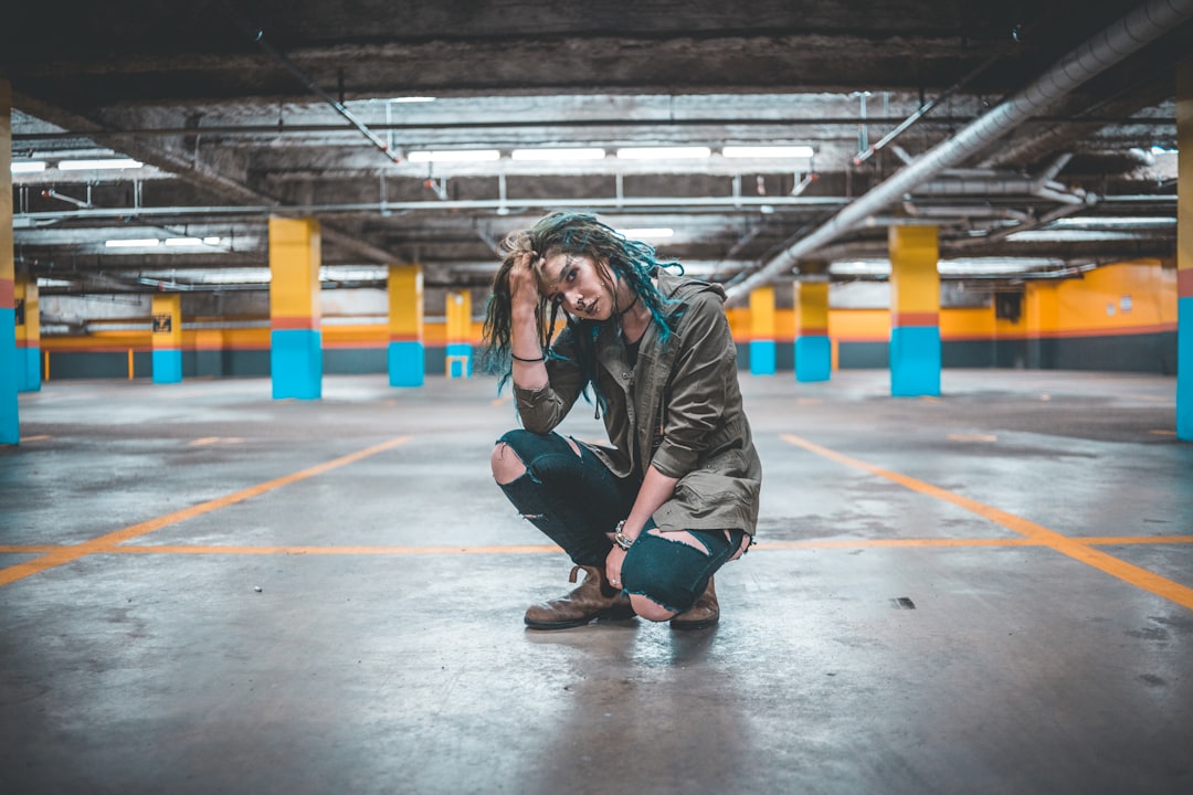 woman touching her hair sitting on parking lot