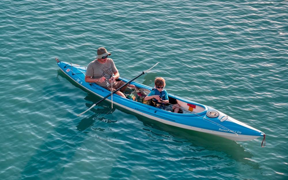 man and boy riding on kayak