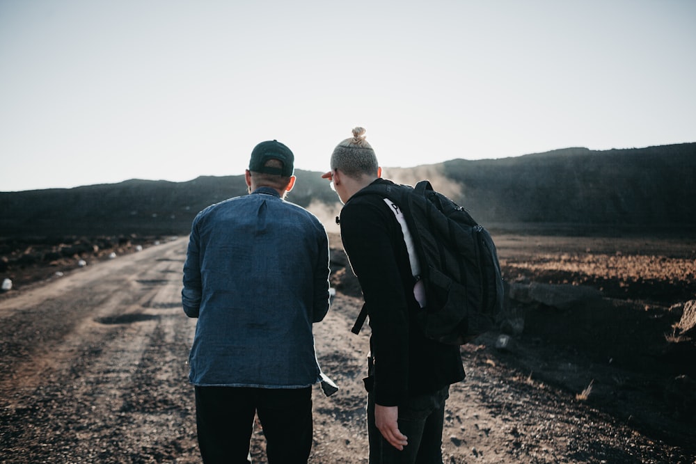 two men standing on brown pathway