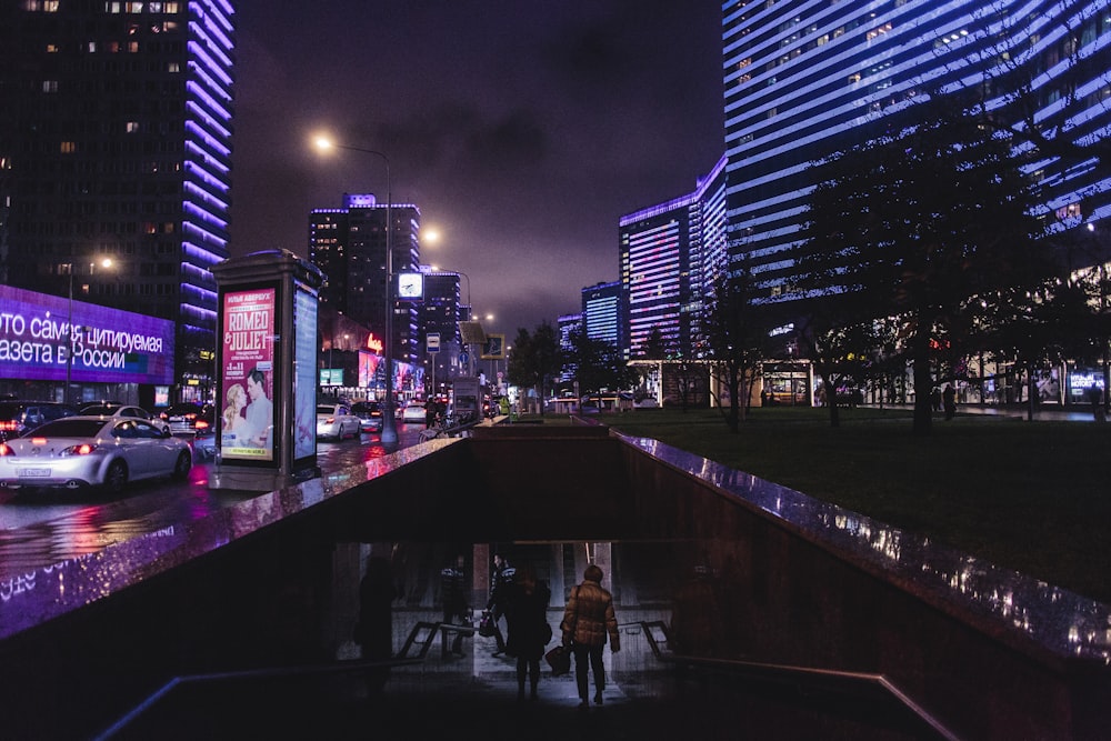 people walking down underground staircase at night