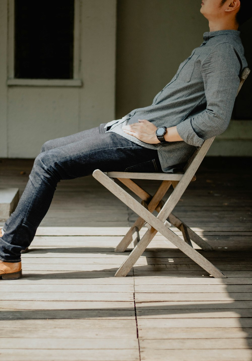 man sitting on brown wooden chair