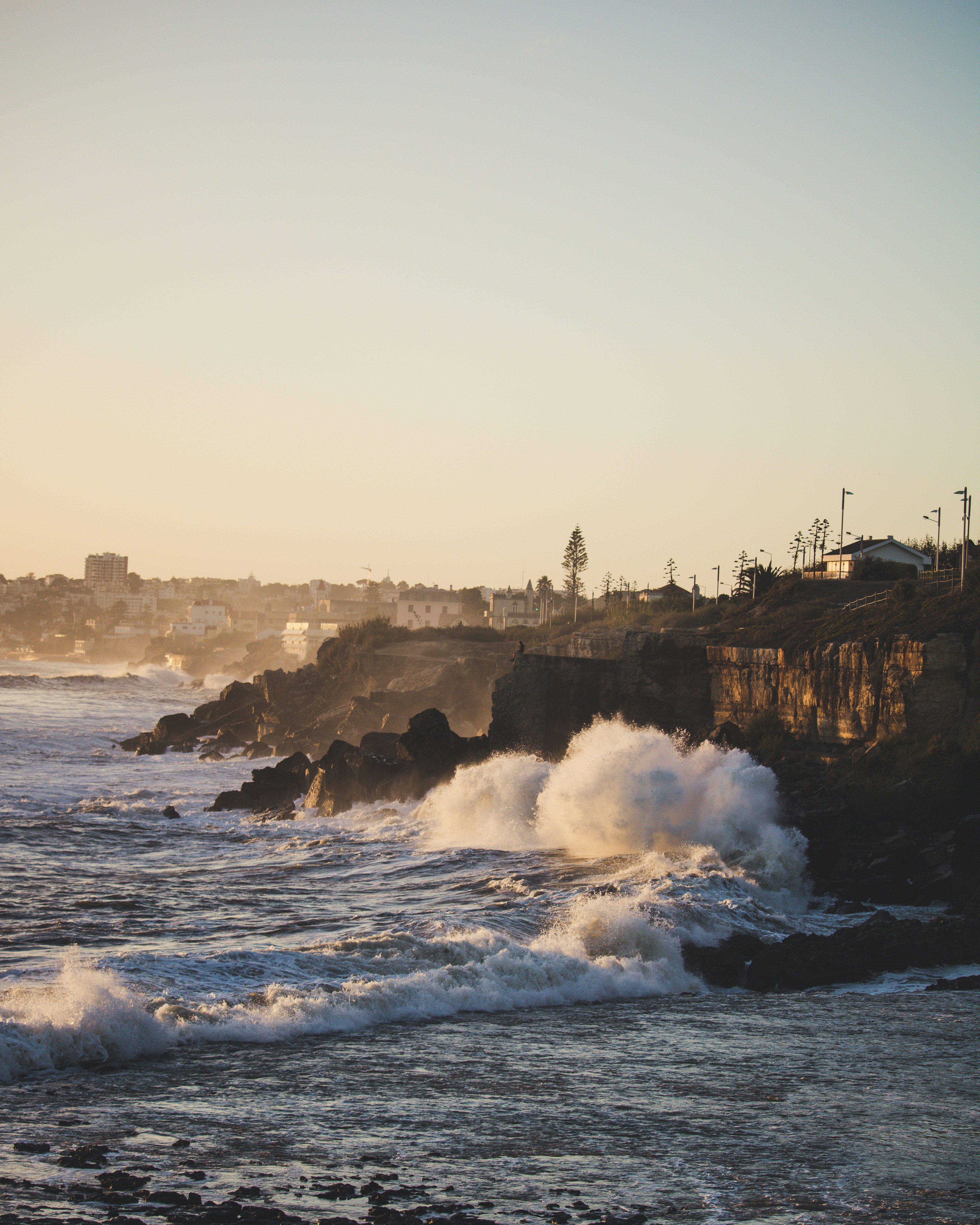 I was walking through the city of Cascais and found this beach. I decide to wait for the sunset to take this photo, the sea was rough.