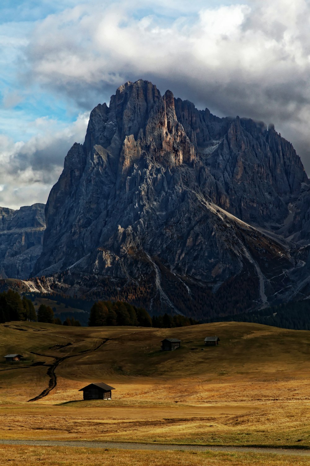 brown mountain and green grass field scenery