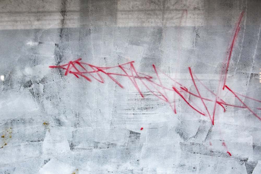 a wall with graffiti on it and a red arrow drawn on it
