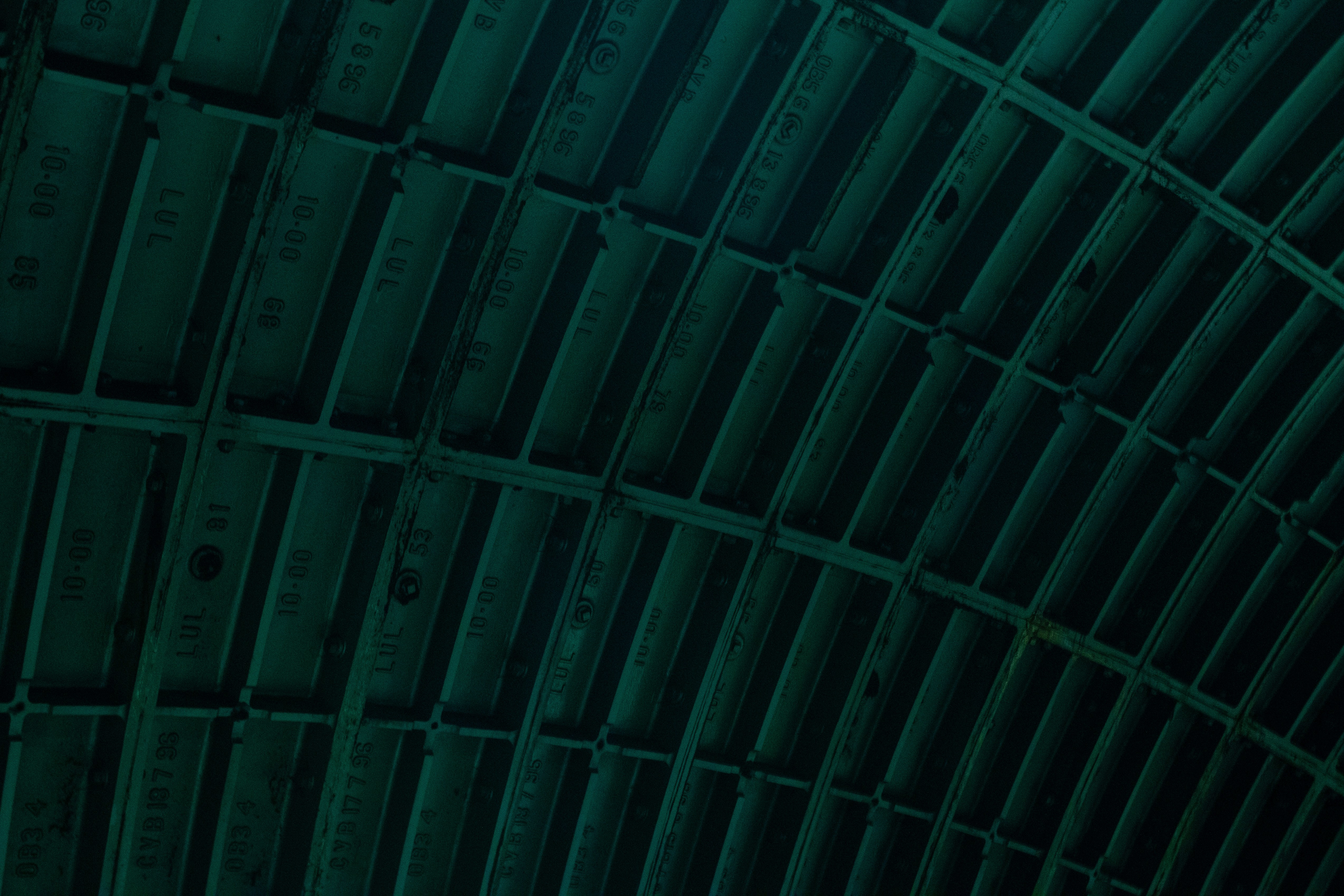 the ceiling of a train station is covered in green tints