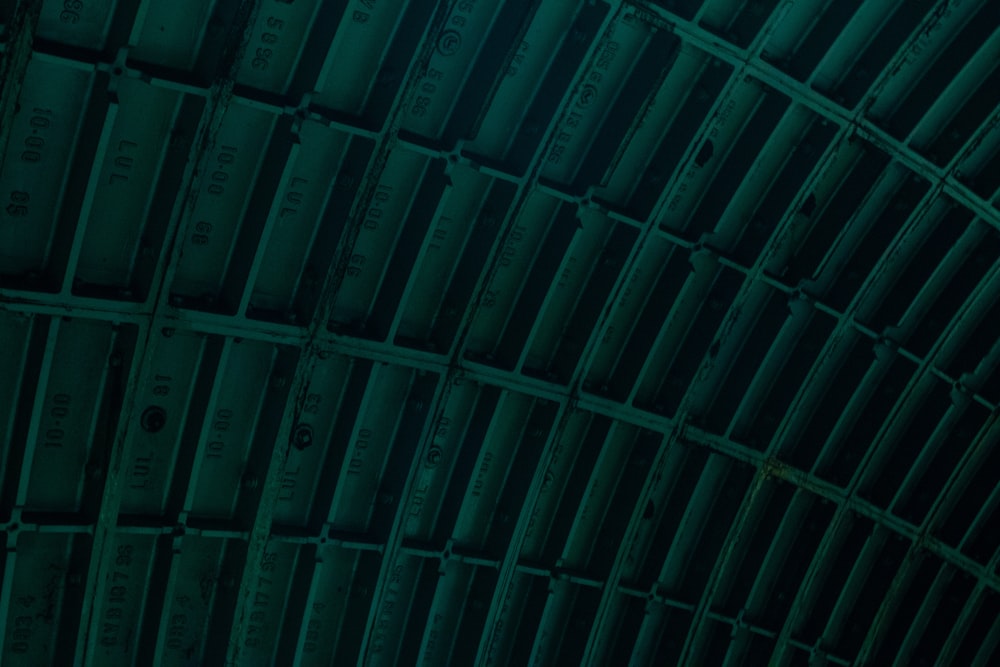 the ceiling of a train station is covered in green tints