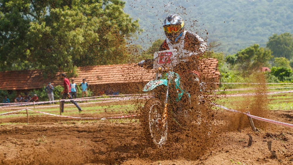 person riding on motocross dirt bike covered with mud