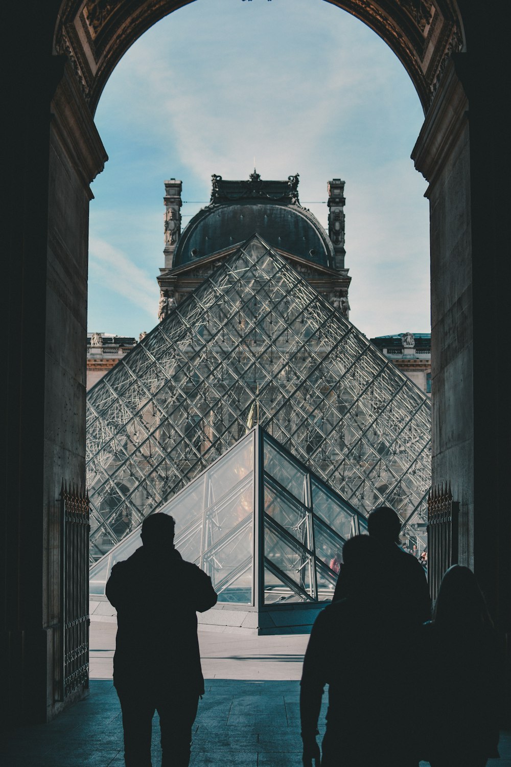 people standing and facing Louvre Museum