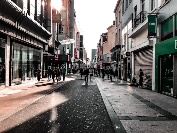 Street-level view of vibrant ground floor retail shops with modern glass facades and bustling foot traffic.