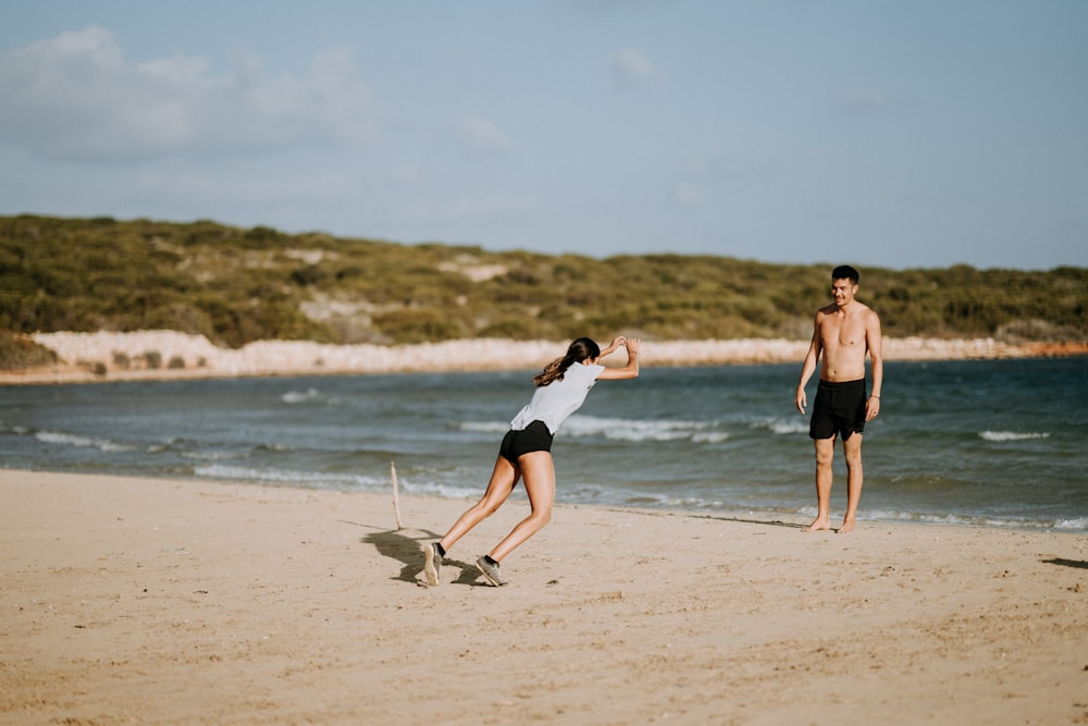 woman and man standing near beach line