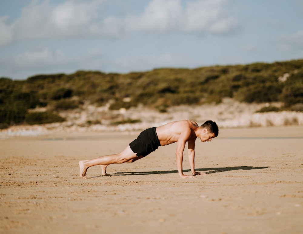 homme faisant des pompes sur le sable