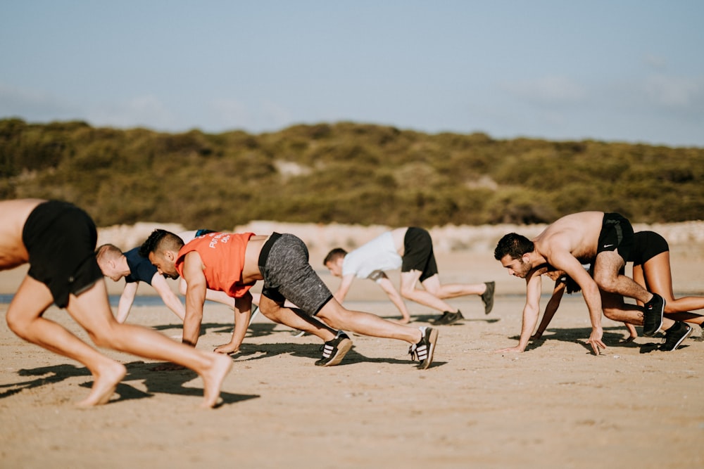 men bending on sand