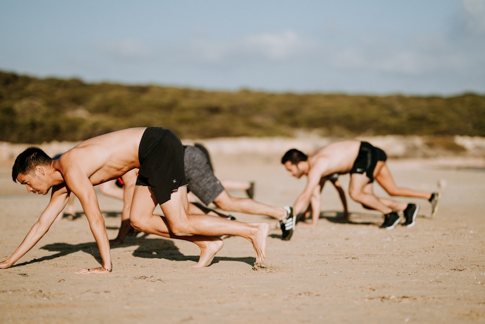 group of men crawling at sand covered ground