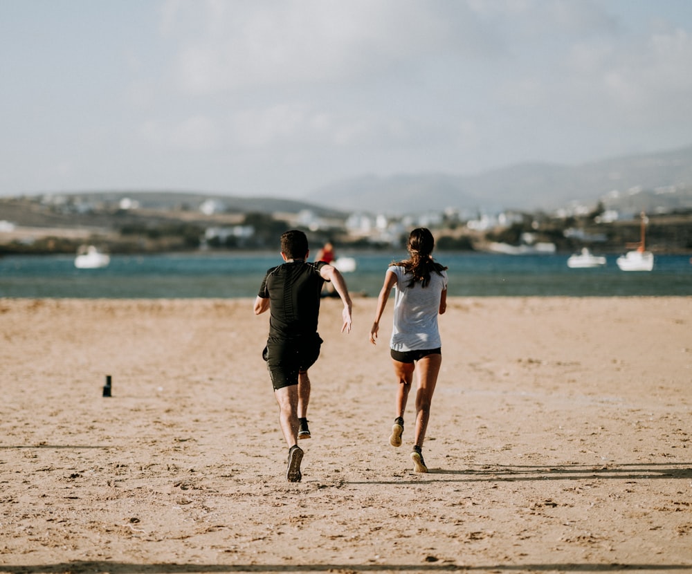 man and woman running on brown field