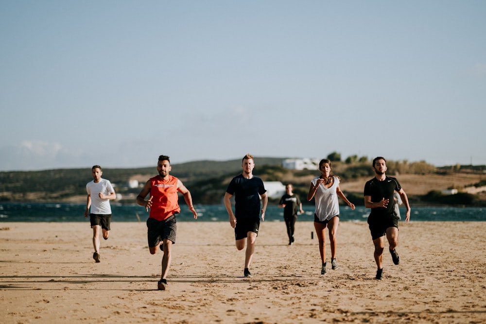 group of men running on beach